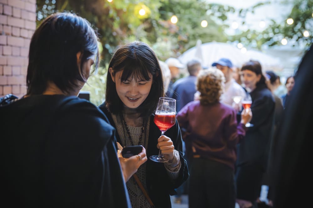 2 guests chatting and looking at their phones