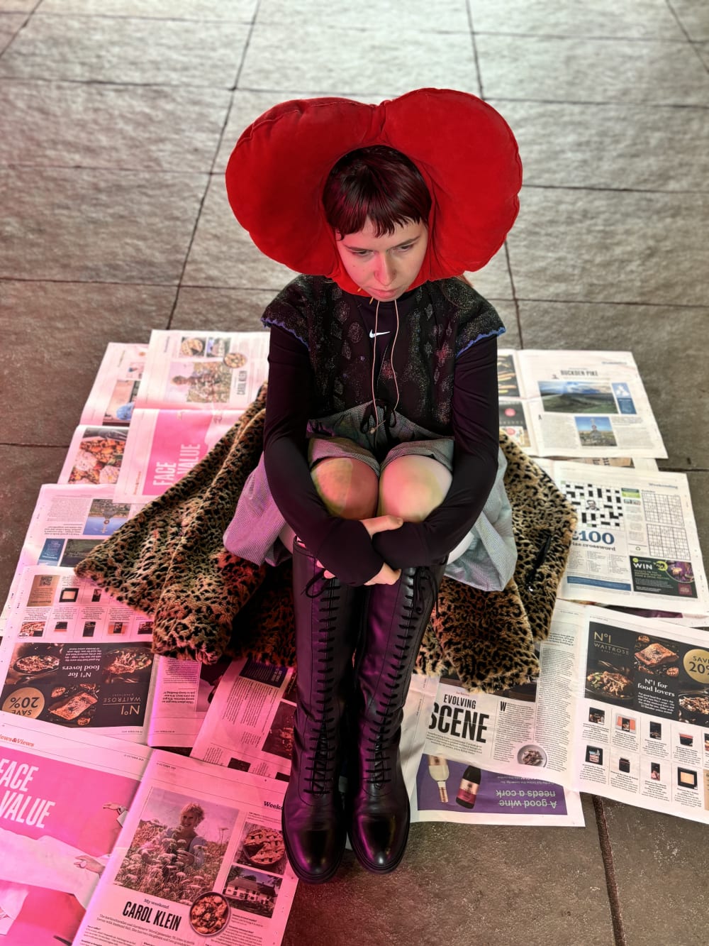 Life-Model in costume of red hear around their head sitting on the floor