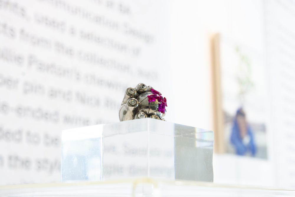 Ring placed on a glass box on a glass table in an exhibition behind glass window