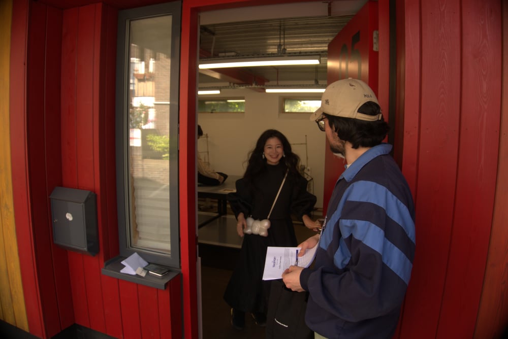 Woman and man standing outside a door looking into a studio.