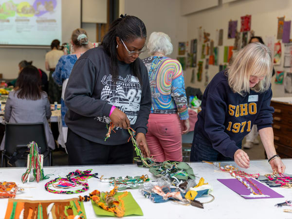 Tutors looking at experimental textile pieces they've created