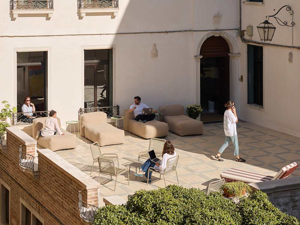 Outdoor working space with people talking on the phone and working on their laptop