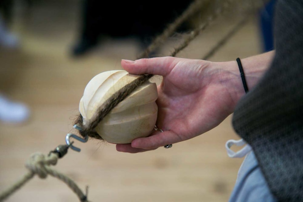 Person interacting with a device made out of hair during an exhibition