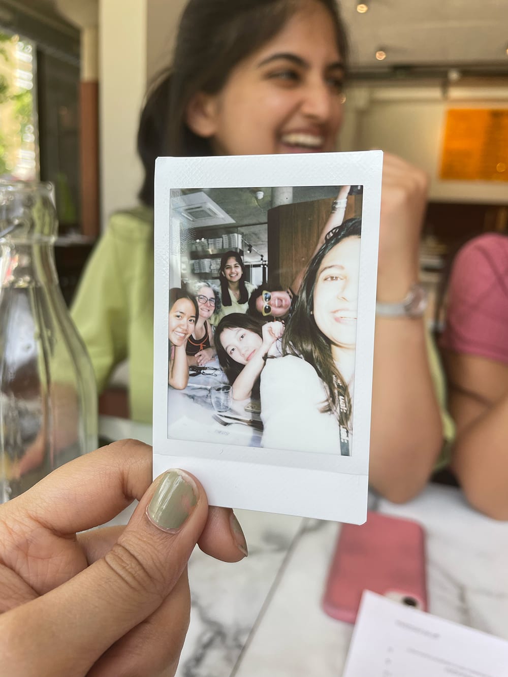 Image of someone holding up a polaroid photograph.