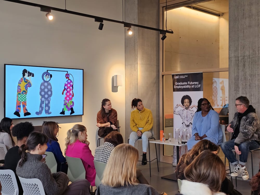 $ members of a panel discussion in front of an audience. 