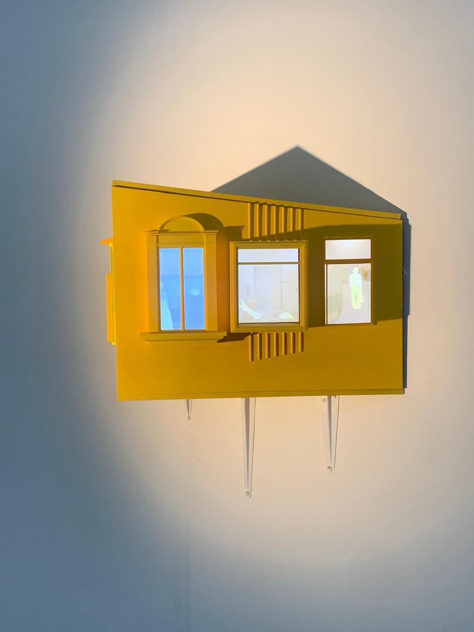 yellow small model house on a wall