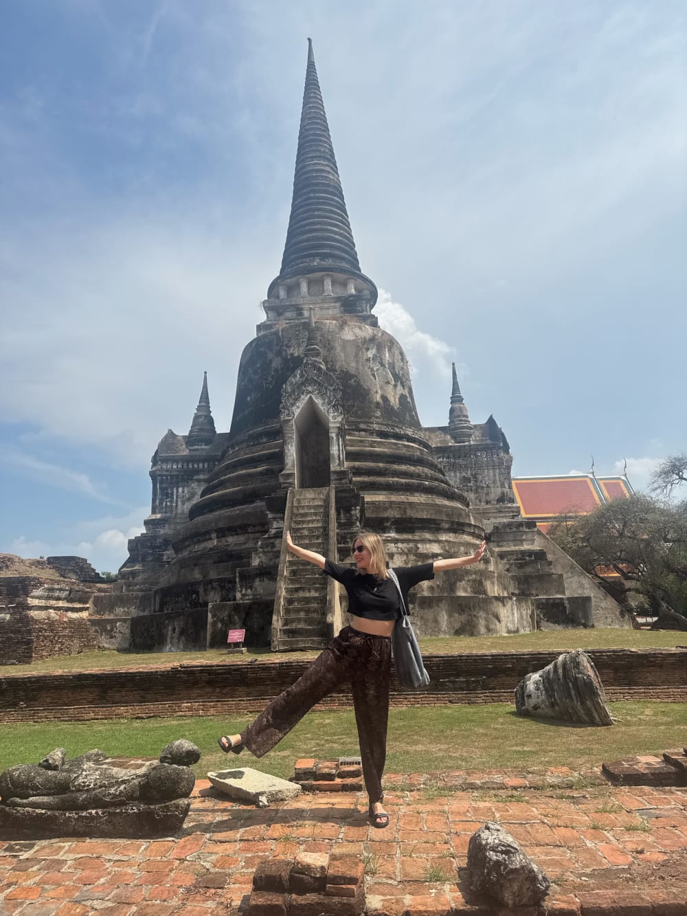 Photo of a woman standing in front of a Thai temple