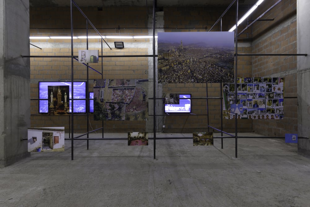 Scaffolding with screens and photos displayed at differing heights