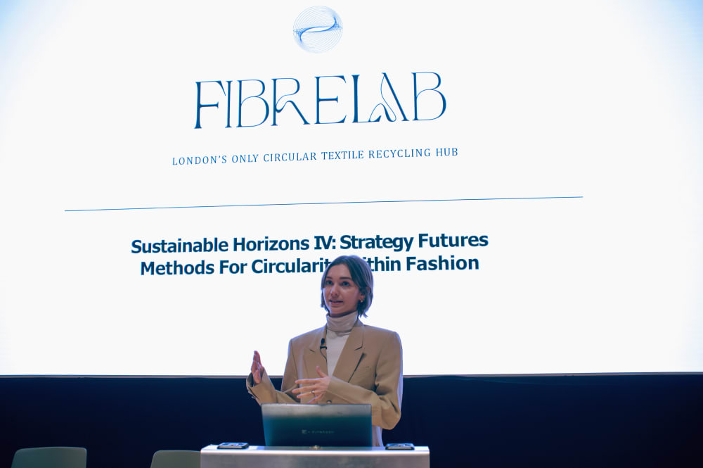 Kaela presenting. Behind her on the screen it says: FibreLab, London's only circular textile recycling hub. Sustainable Horizons IV: Strategy Futures. Methods for Circularity Within Fashion'