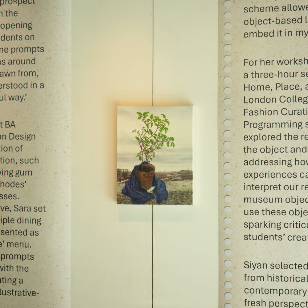 Paining of a plant exhibited in a window gallery and placed in between two posters featuring written text.