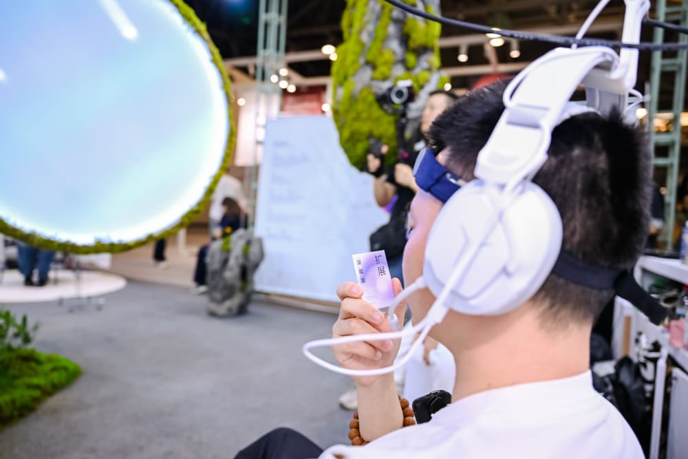 person wearing white headphones at a tech design exhibition
