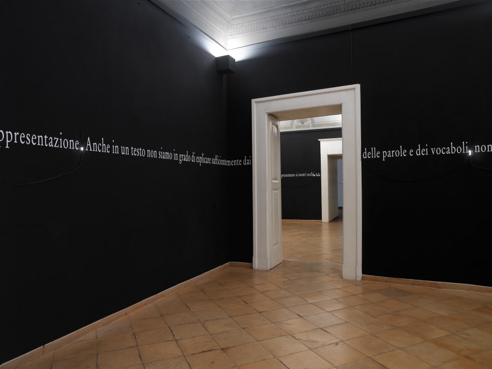 A black room with a border of white writing on the walls