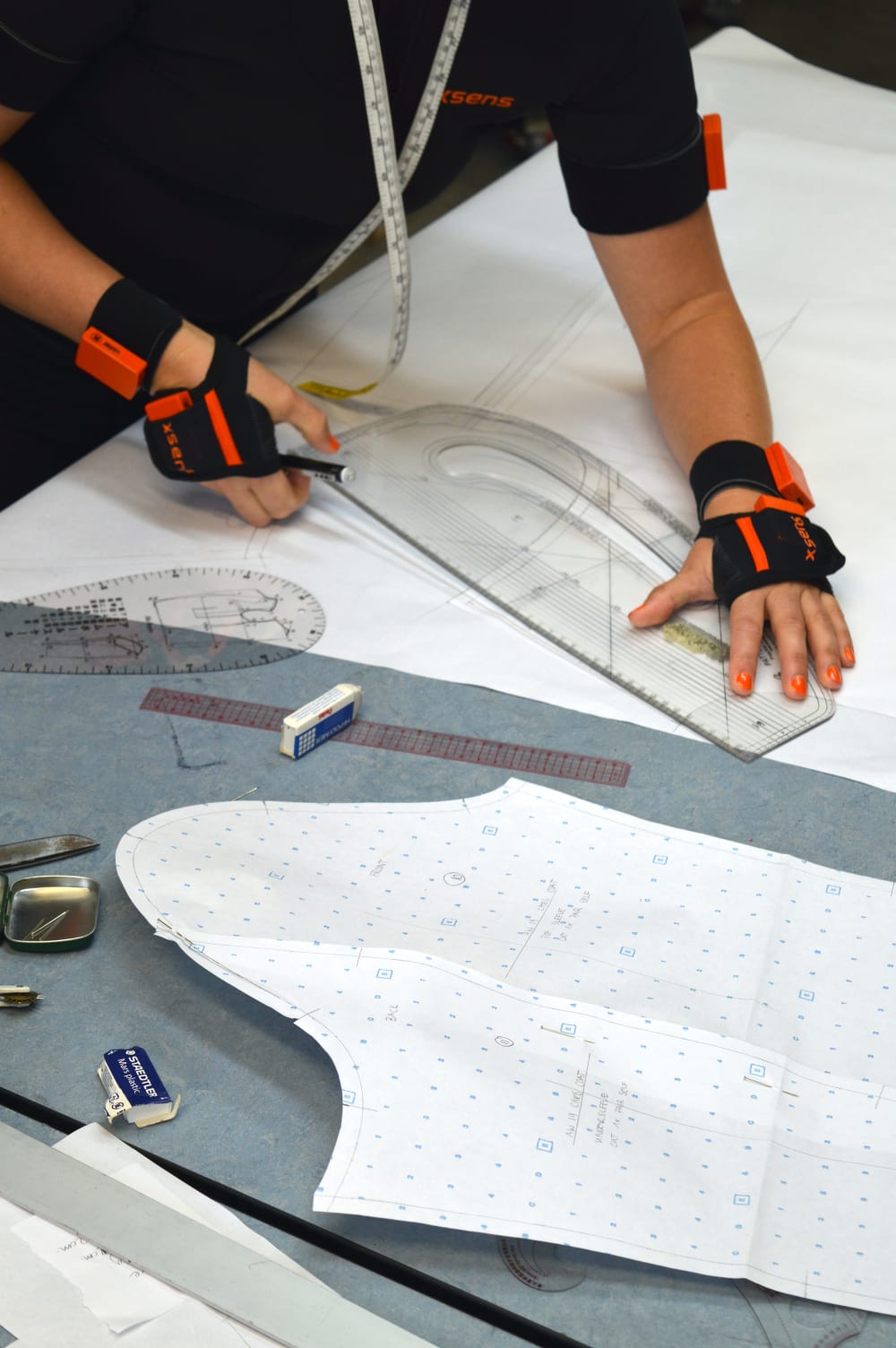 Image of Tessa working on her MA project using garment ruler and measuring tape around her neck