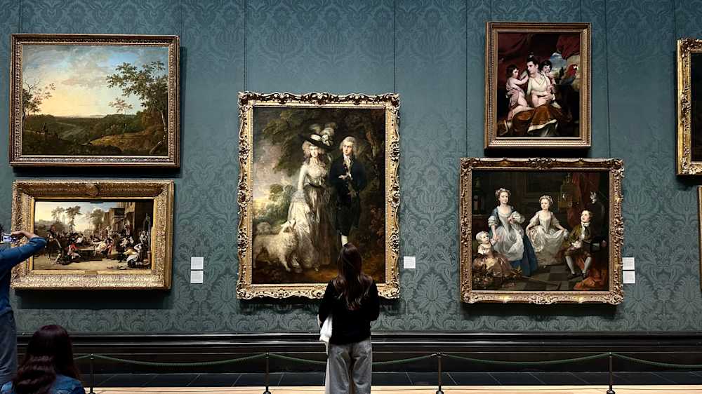 Violeta standing in front of large, French paintings at an art museum
