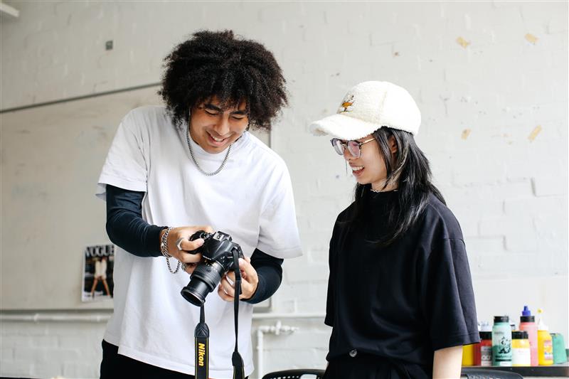 Two students looking at an image on a camera