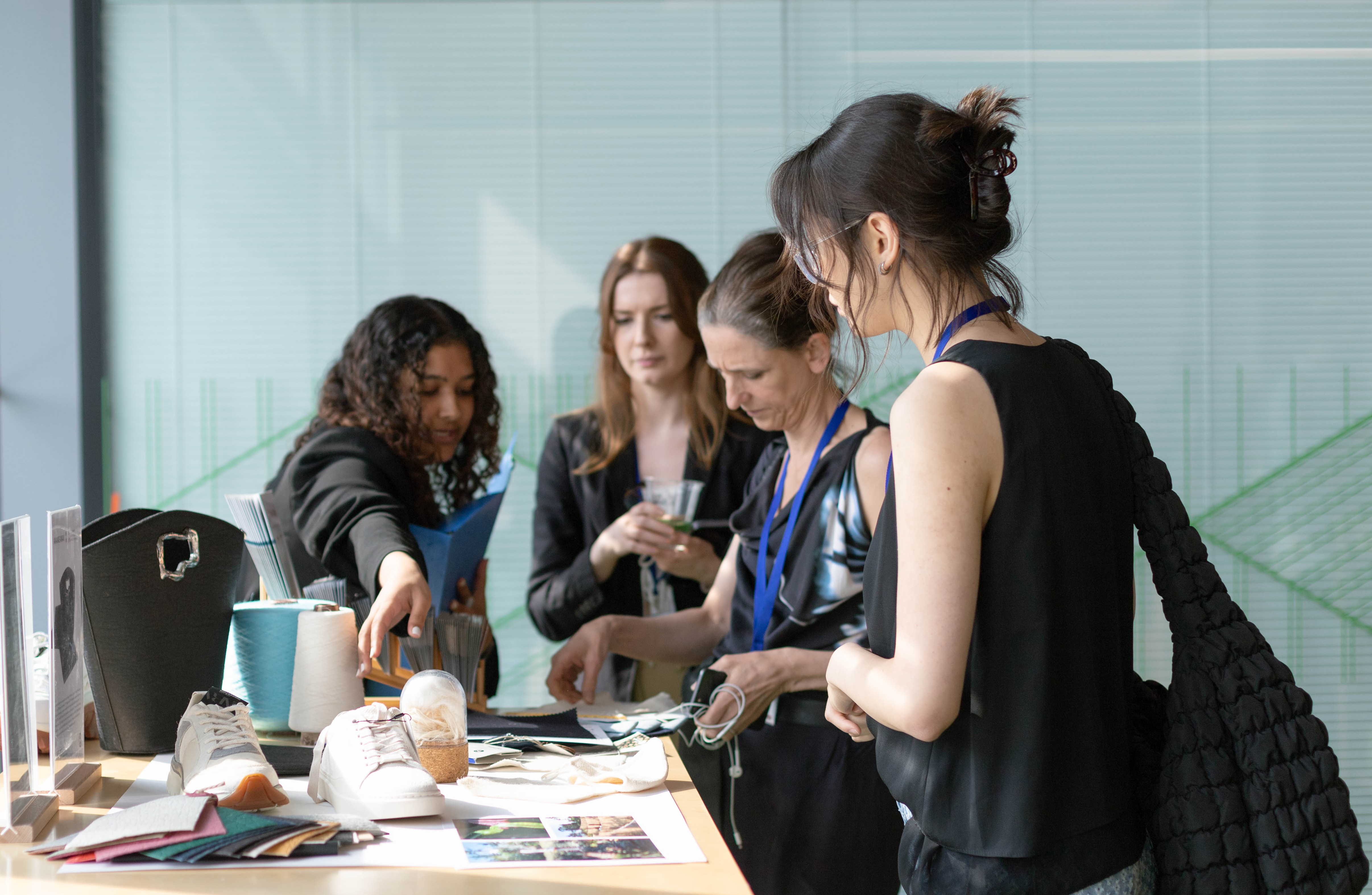 a group of people are gathered around a table with fashion items on it