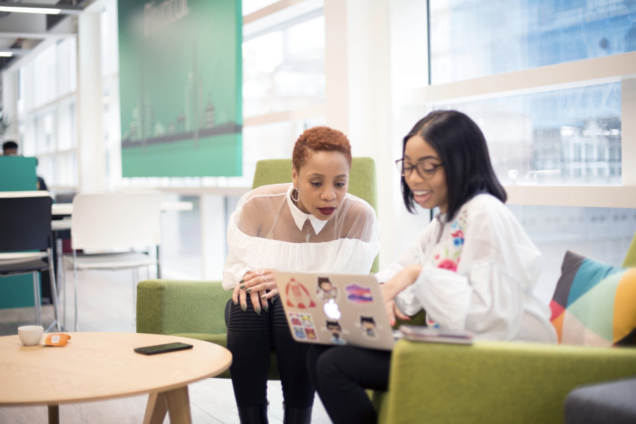 Two people talking and looking at a computer screen