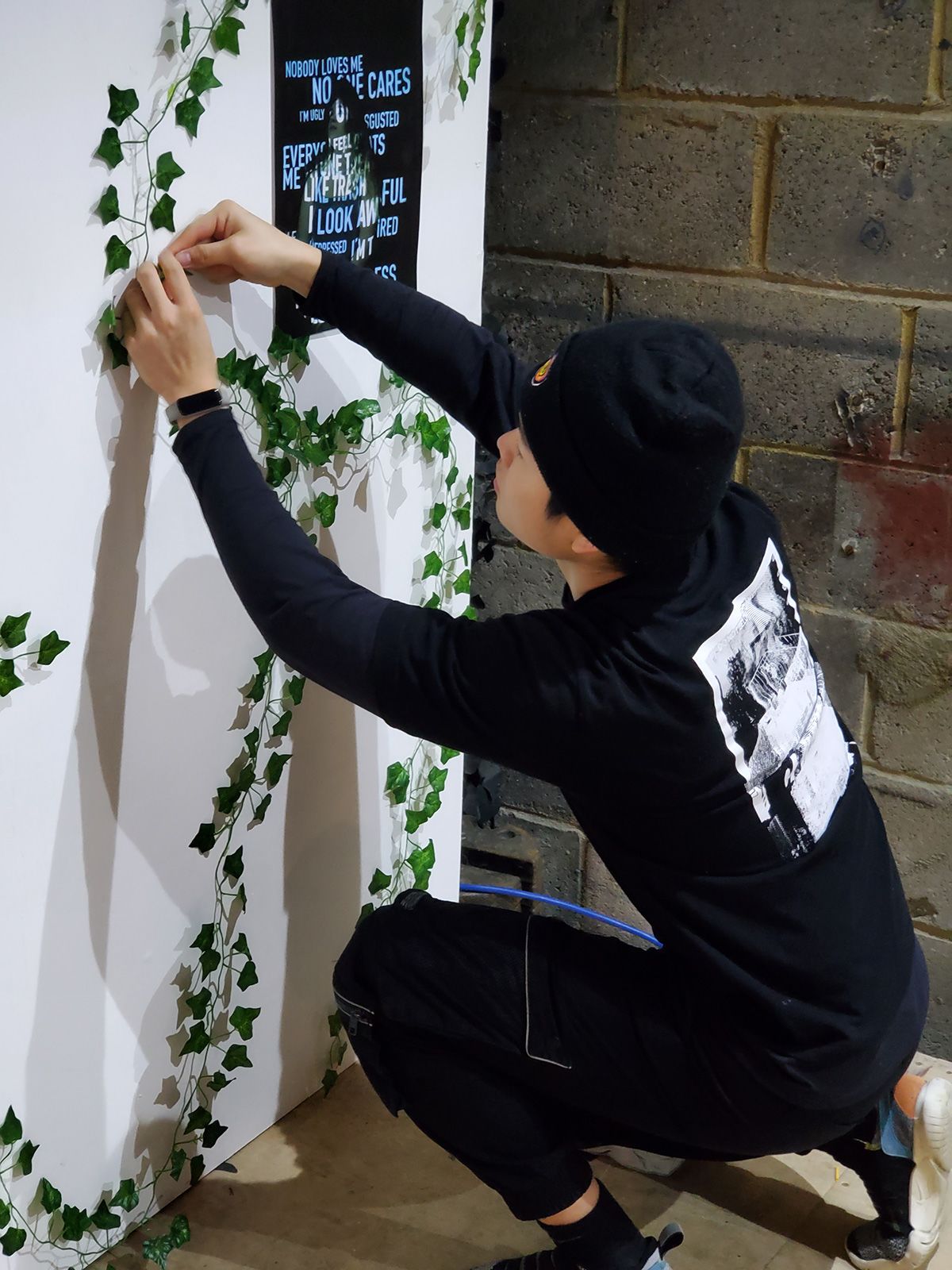 A man crouches down to assemble an exhibition wall.