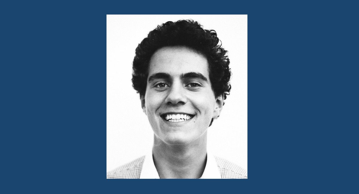 A greyscale portrait of a smiling man.