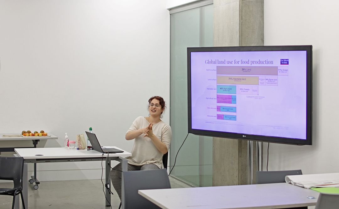 Nicole sat in front a screen which displays statistics on global land use for food production