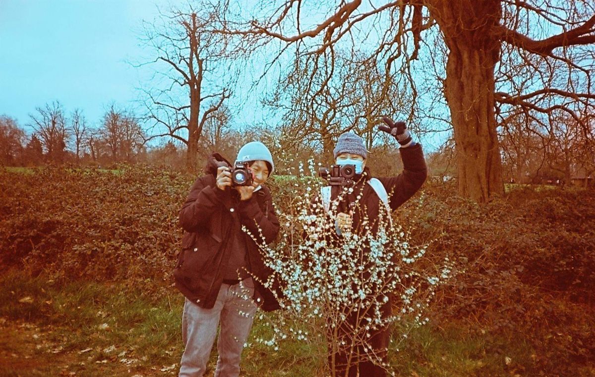 Photograph of two people in a forest setting.