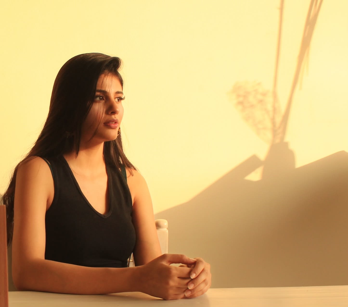 portrait of sitting woman shaow on wall behind