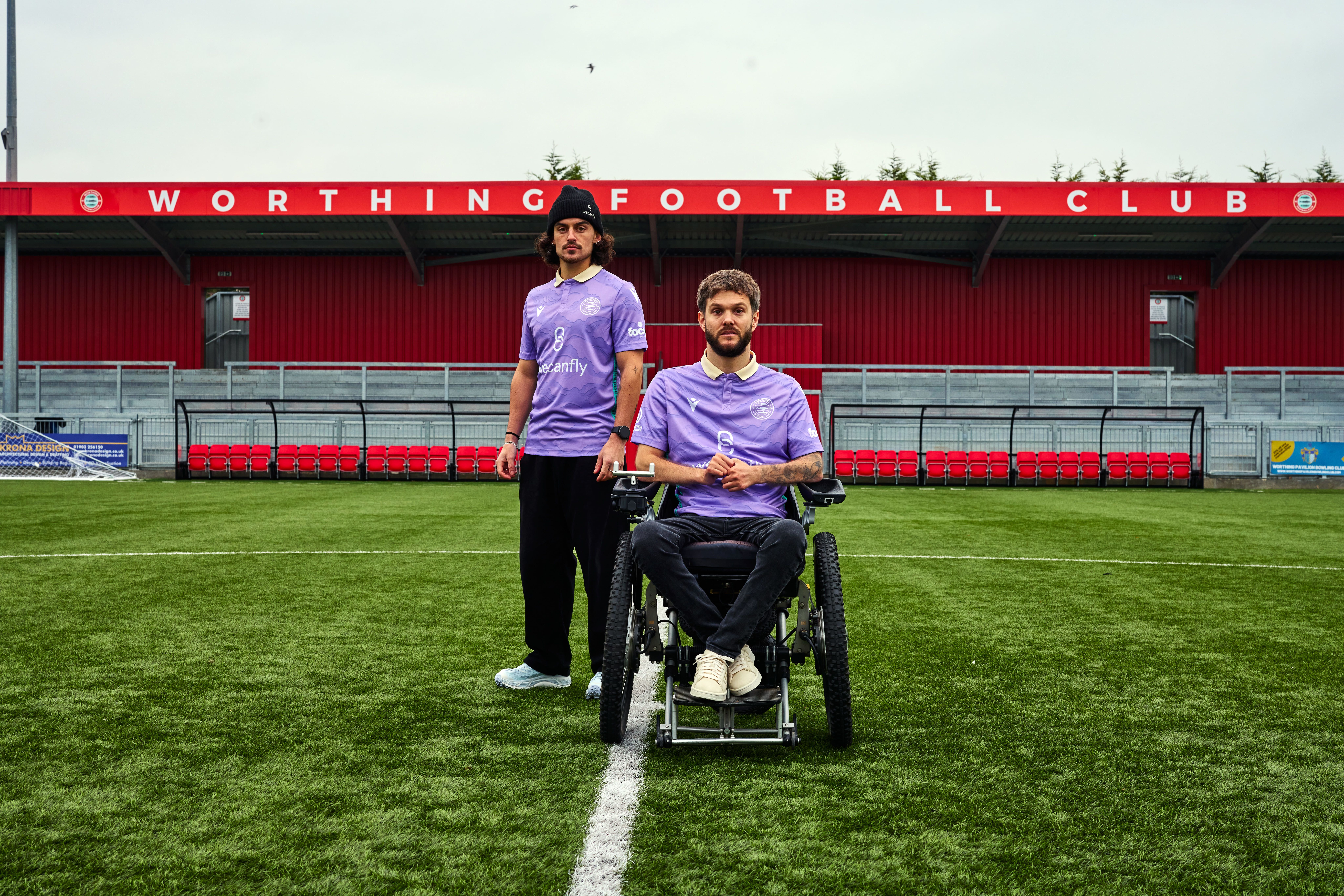 Two men standing on a football pitch.