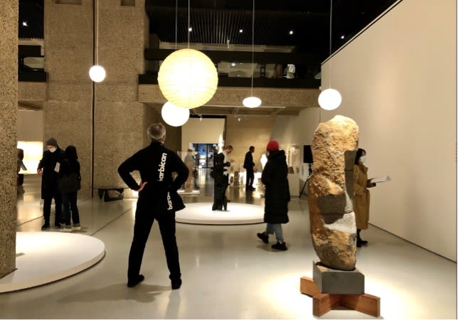 People stood looking at sculptures in a gallery