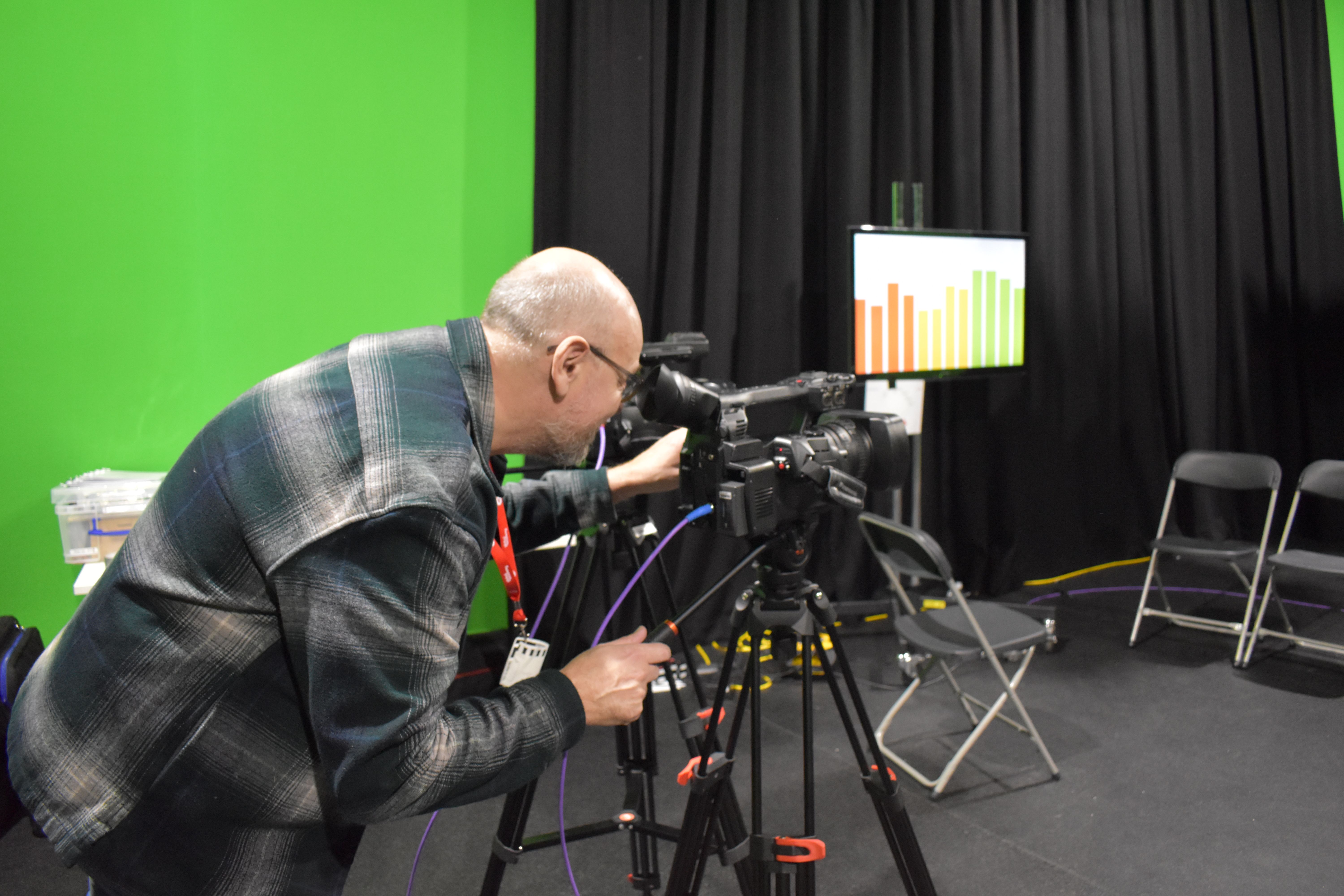 Person standing behind camera directing