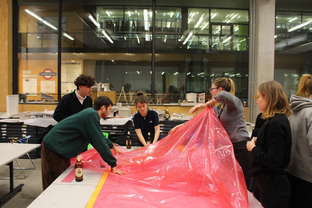 Students working at Making Things Social pulling on a red, plastic fabric