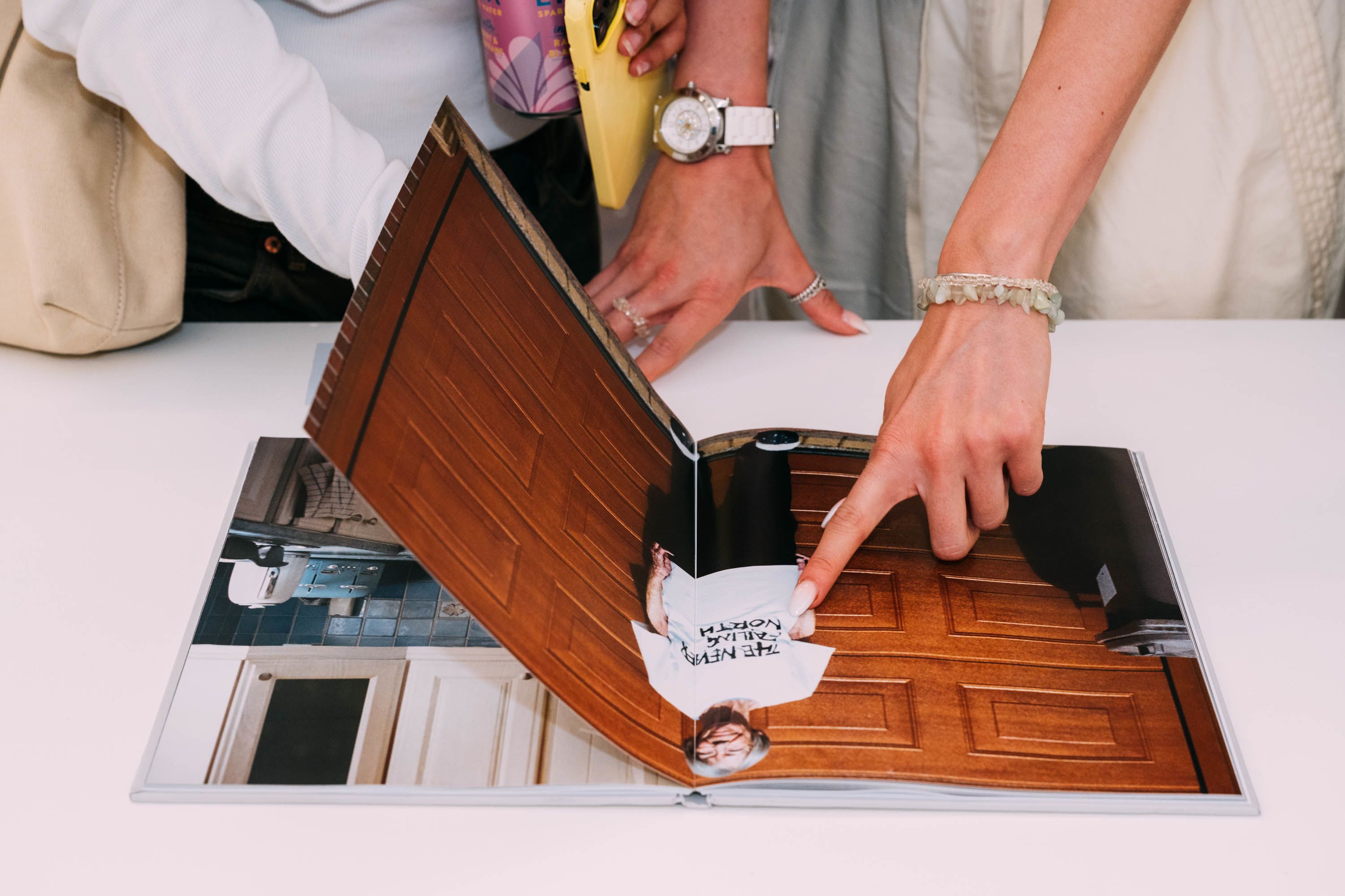 Close up of a person's hand pointing in a magazine