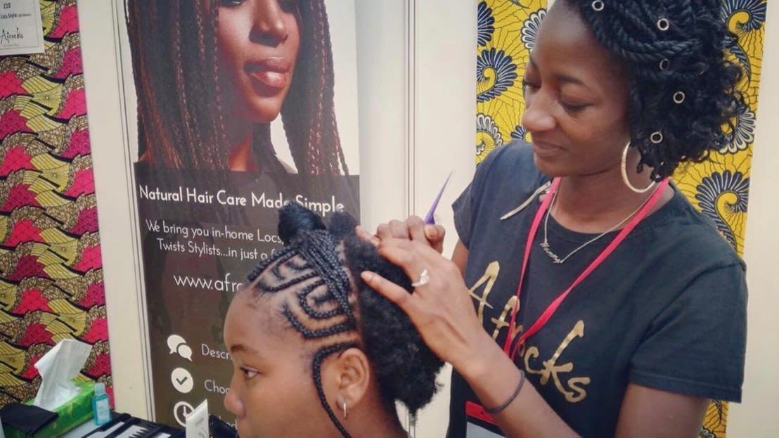 woman braiding a young girls hair