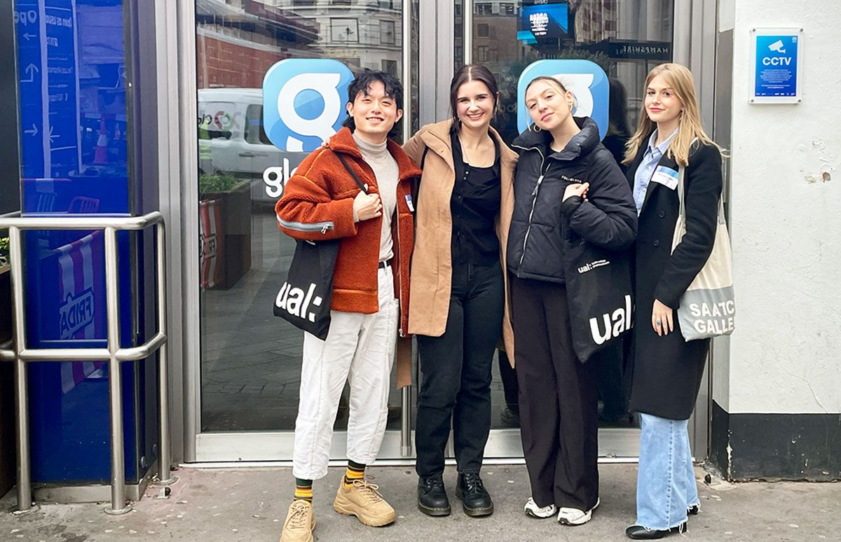 Image of four students standing outside a media office.