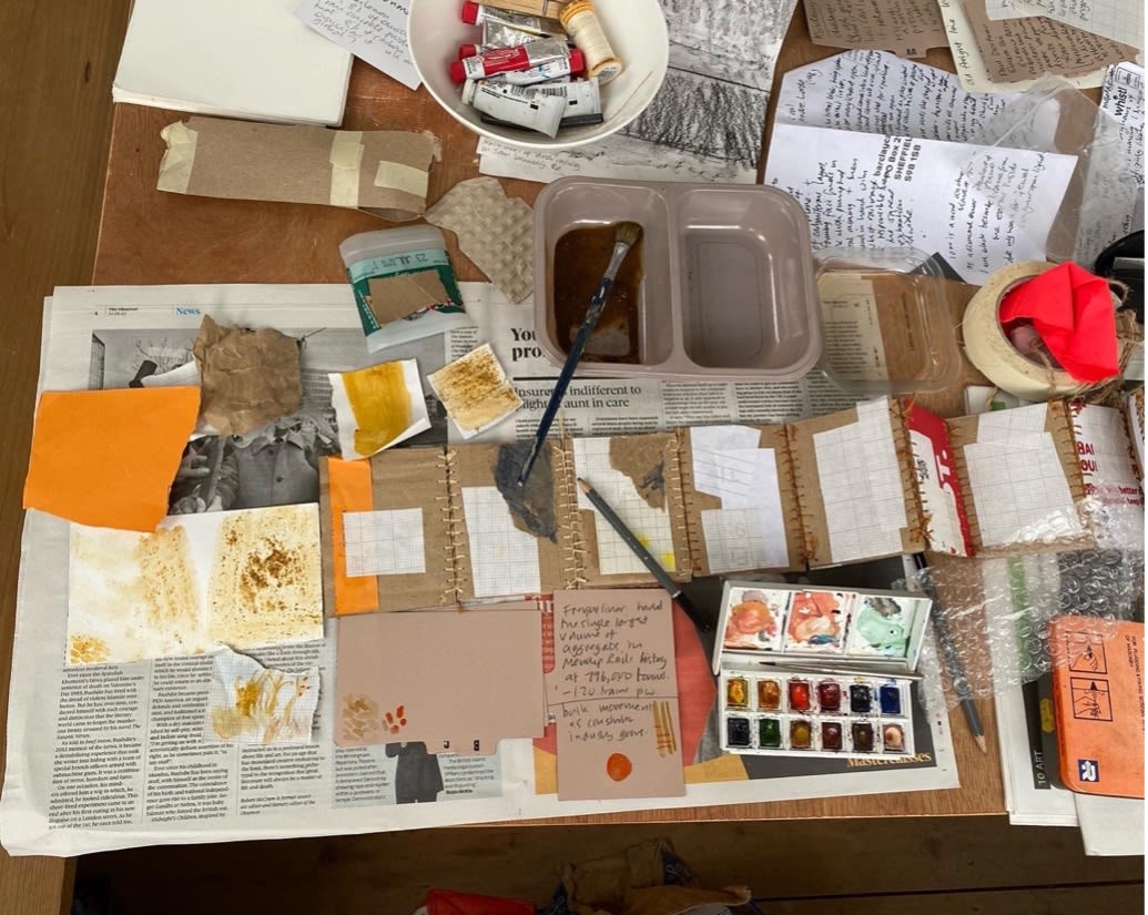 A table covered in newspaper paints and paper