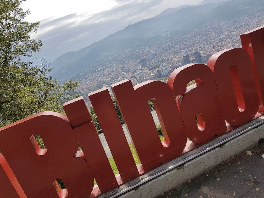 A sign made of large red letters making the word Bilbao, shot from high overlooking Bilbao city