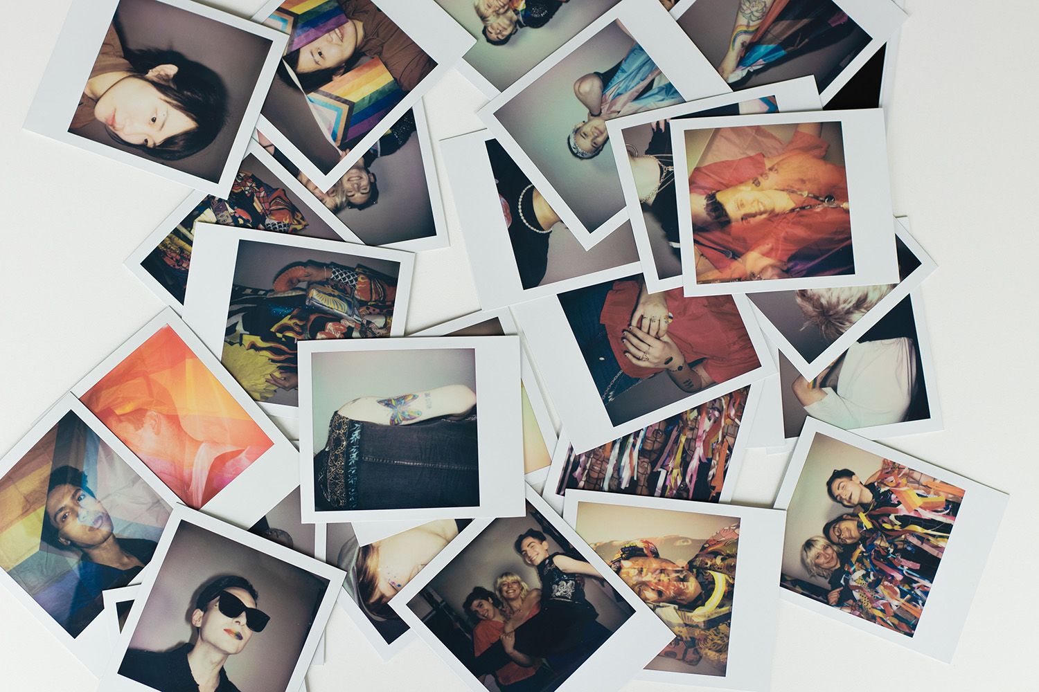 Colourful Polaroid images scattered across white table
