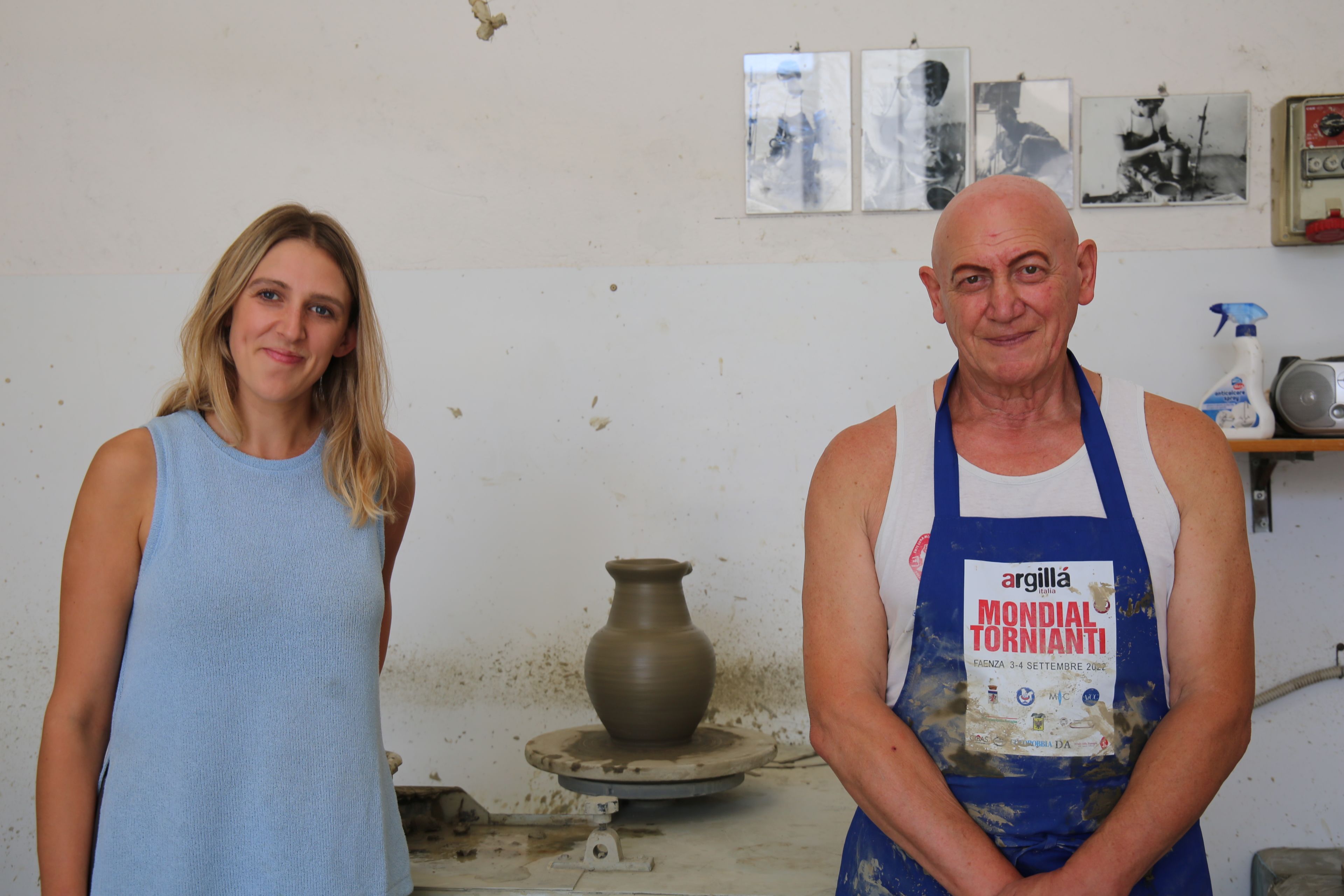Carly and a man stood in front of a freshly made clay pot