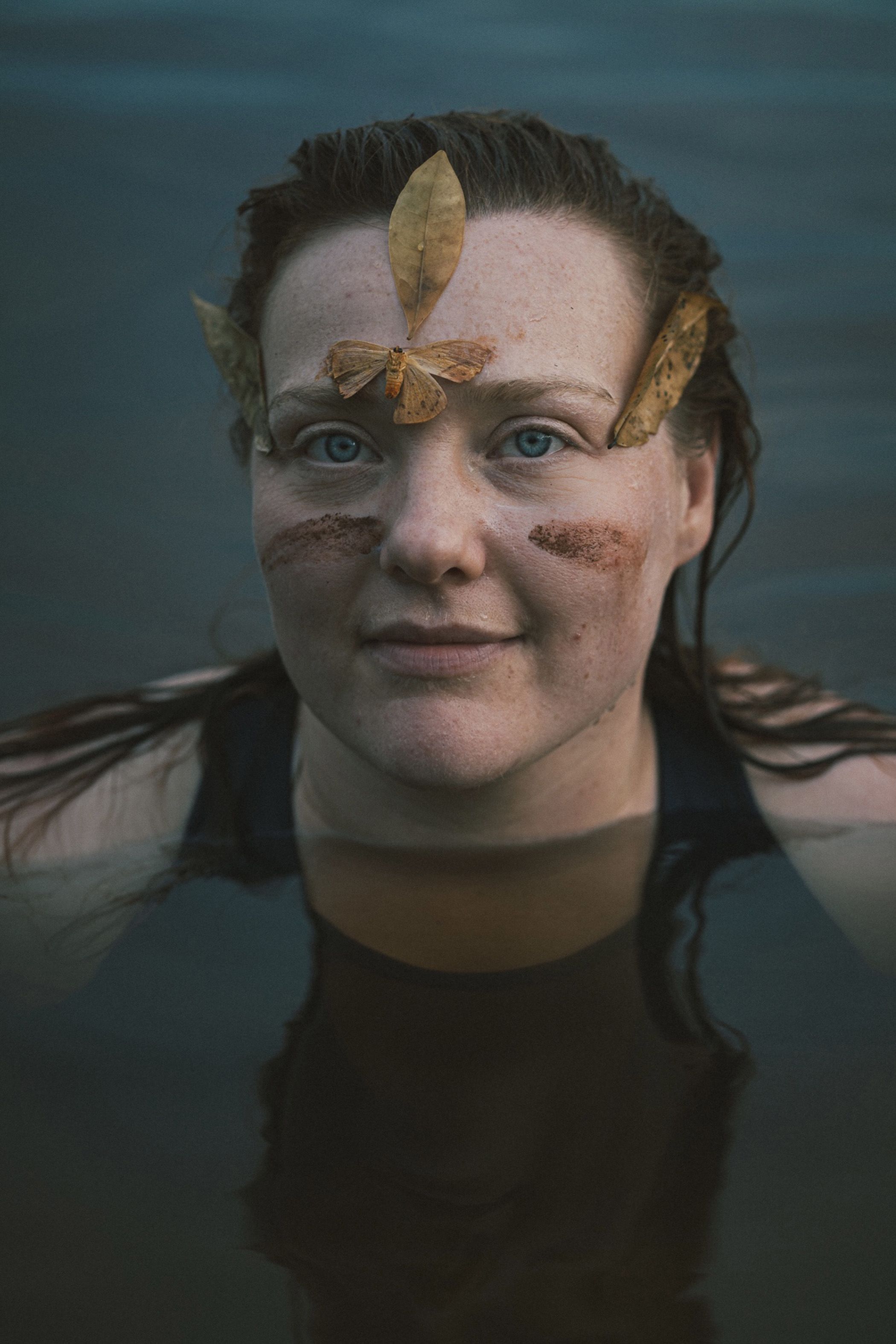 A woman popping her head out of a lake