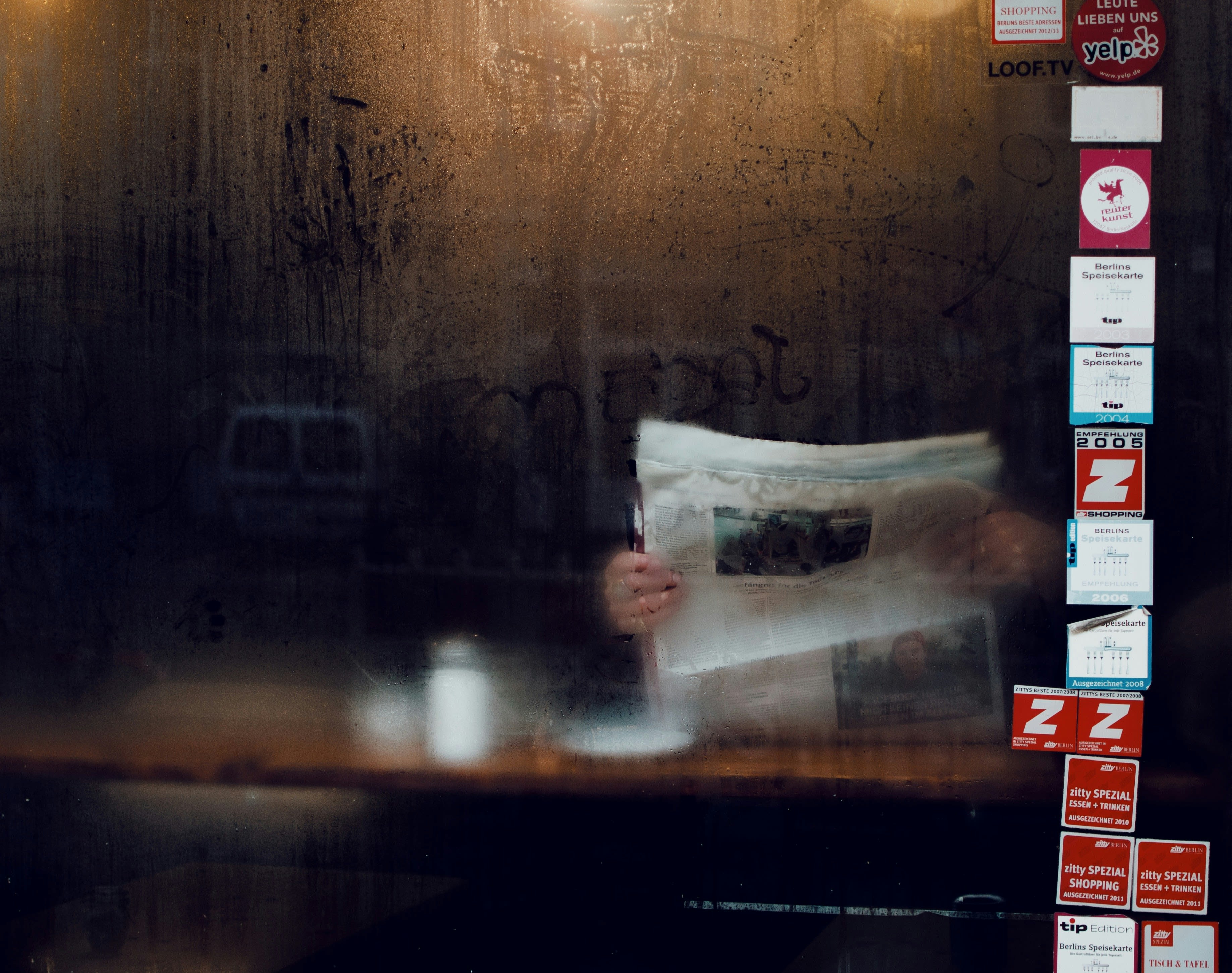a blurry photo of someone reading a newspaper