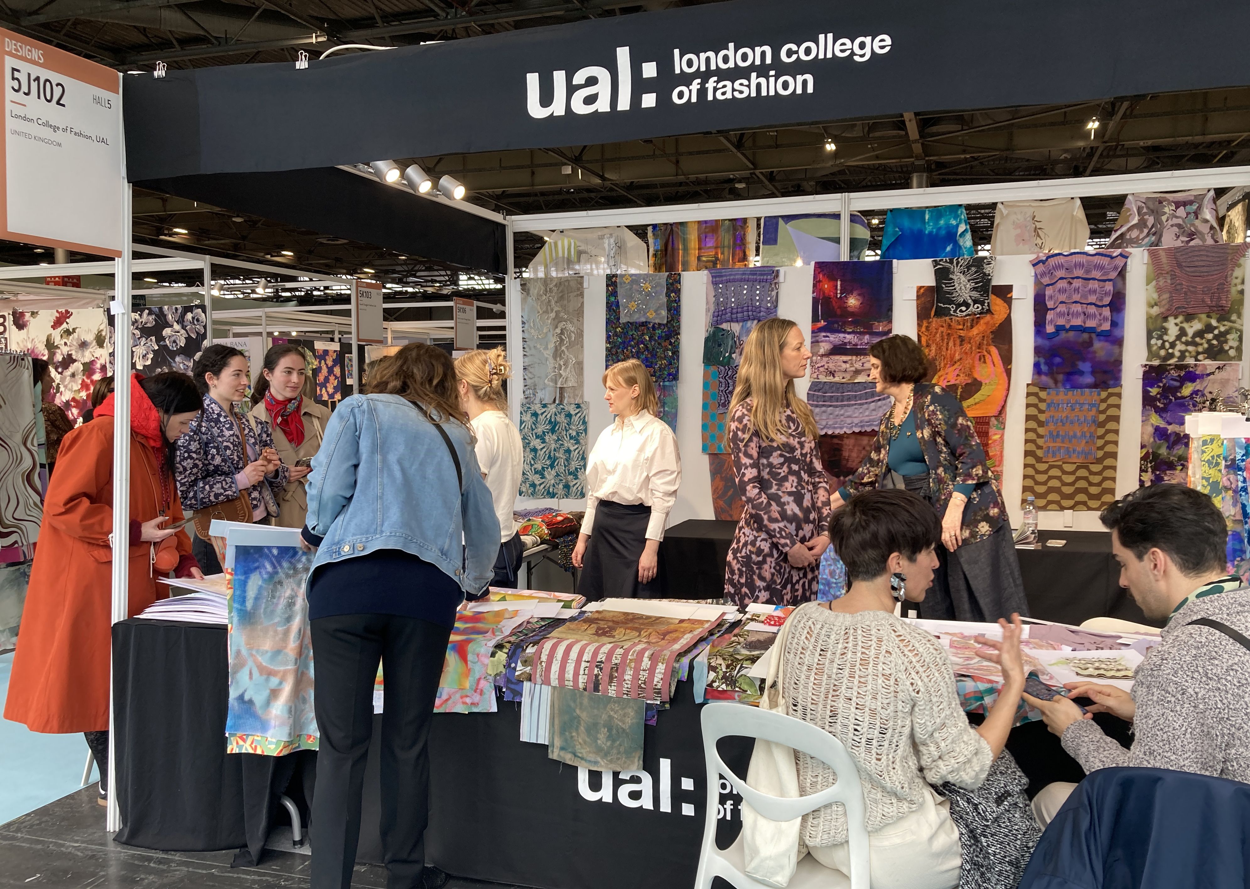 People standing around an exhibition stand with textile samples