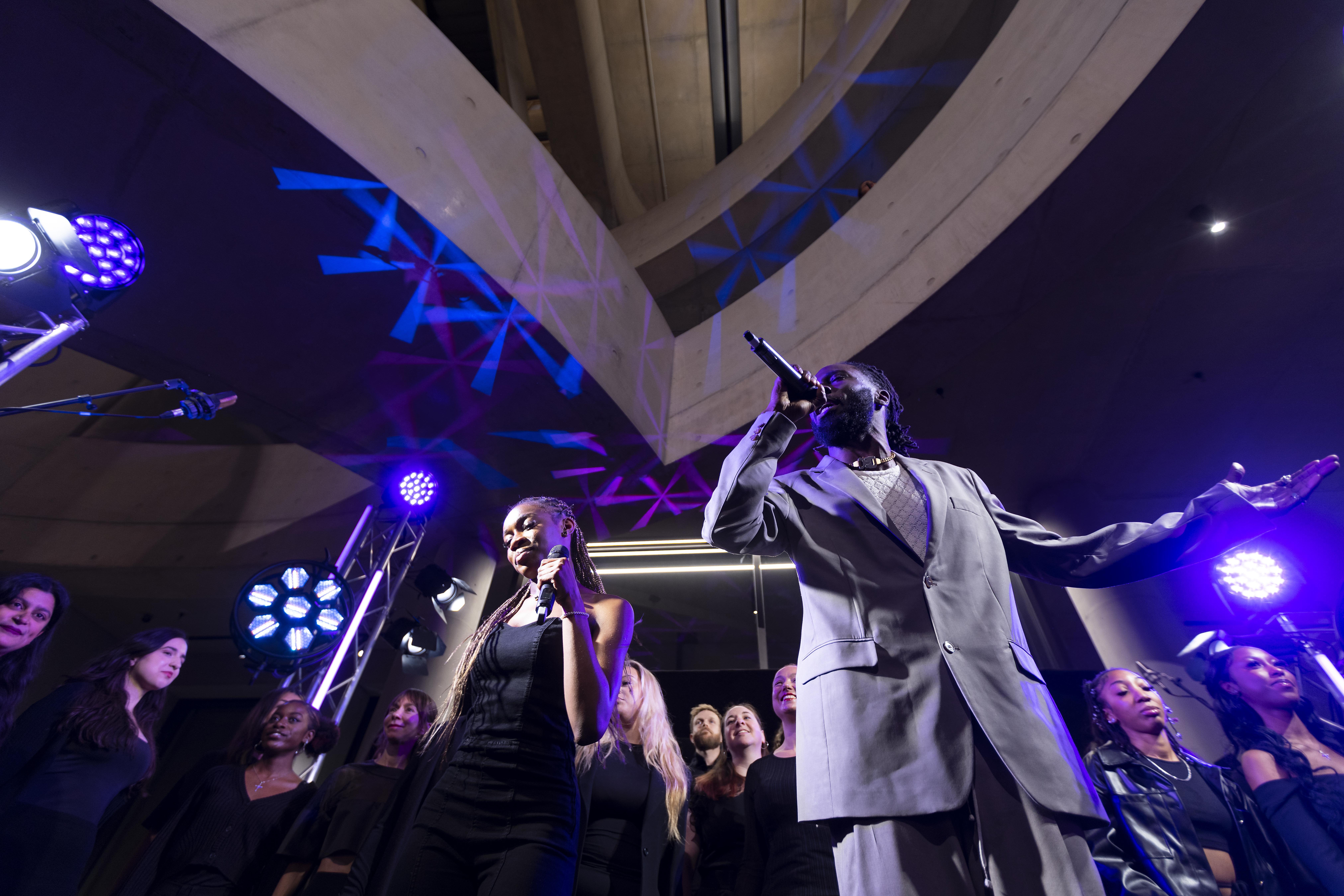 Kojey Radical and Angel singing on stage with choir behind