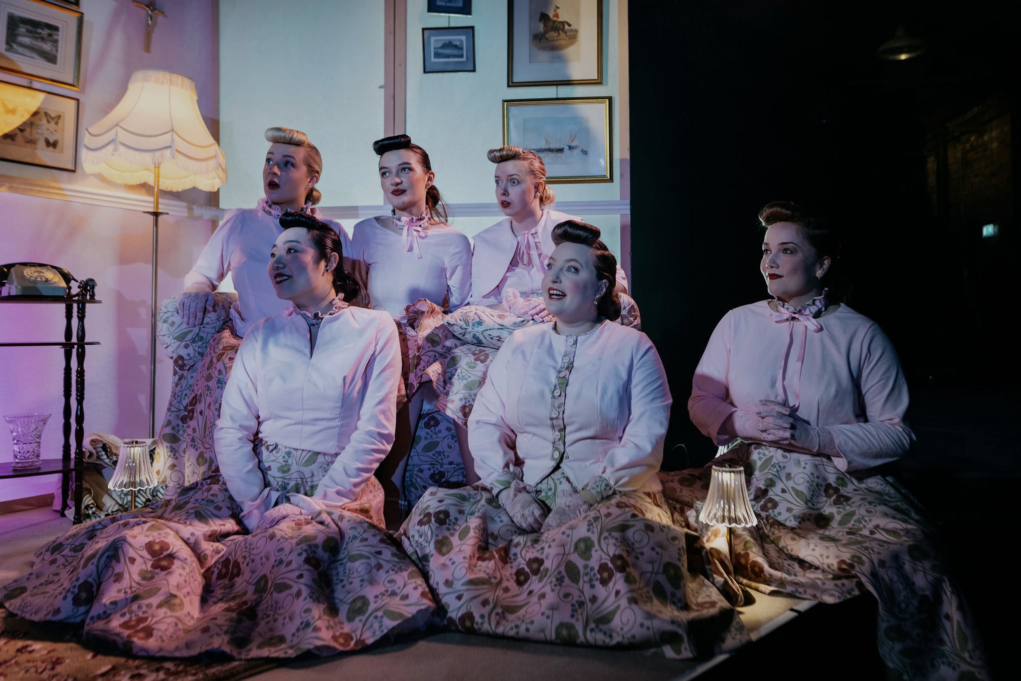 Group of women dressed in pink singing. 