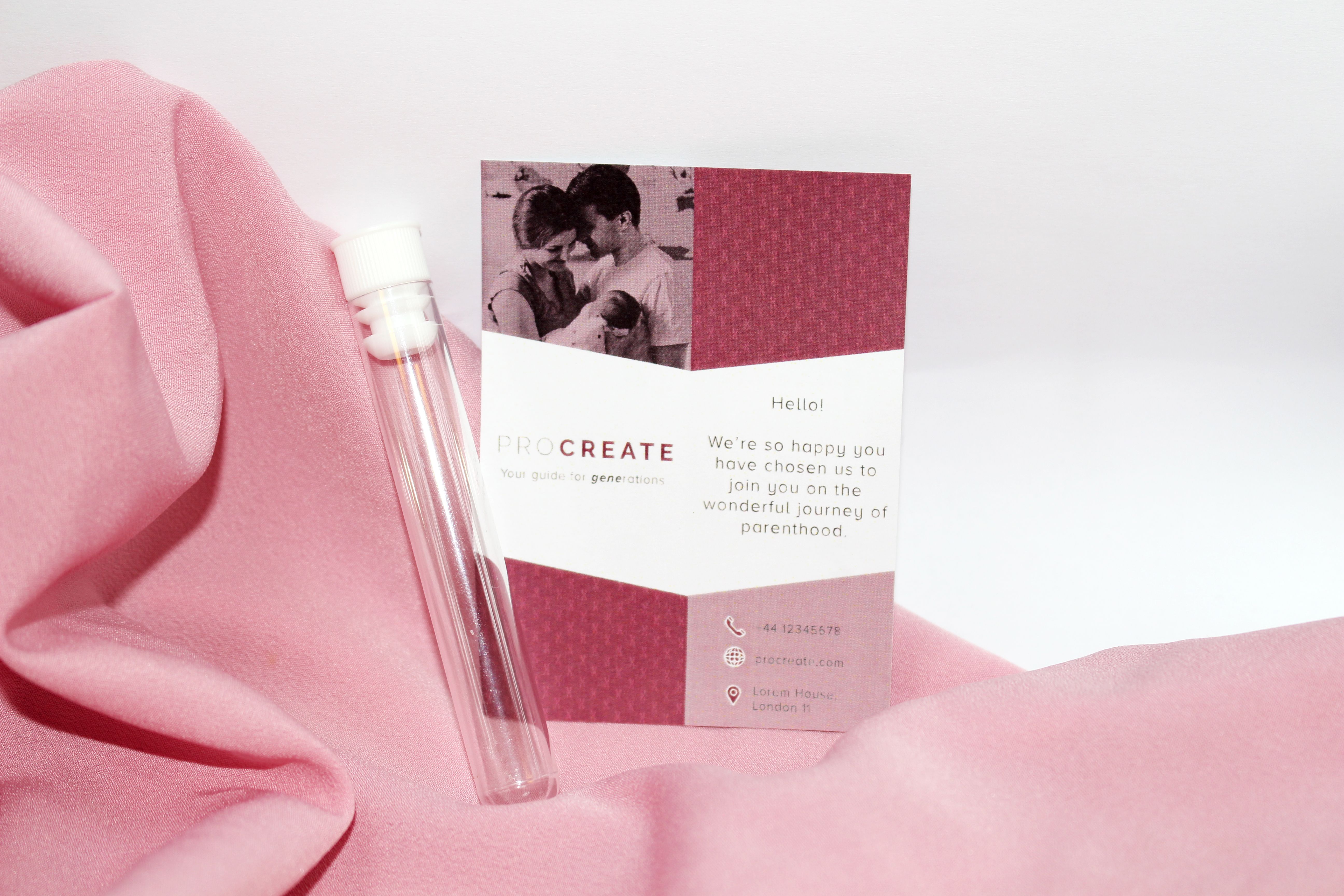 A leaflet about parenthood next to a test tube ontop of a pink satin sheet