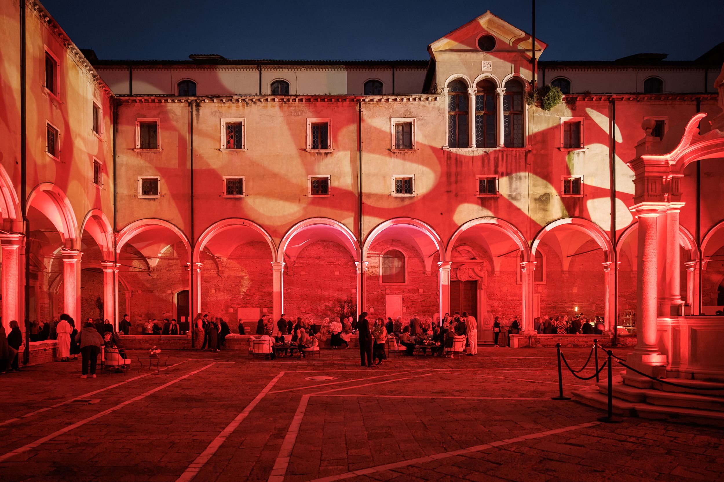 An old building with a red and white light show projected onto it's facade.