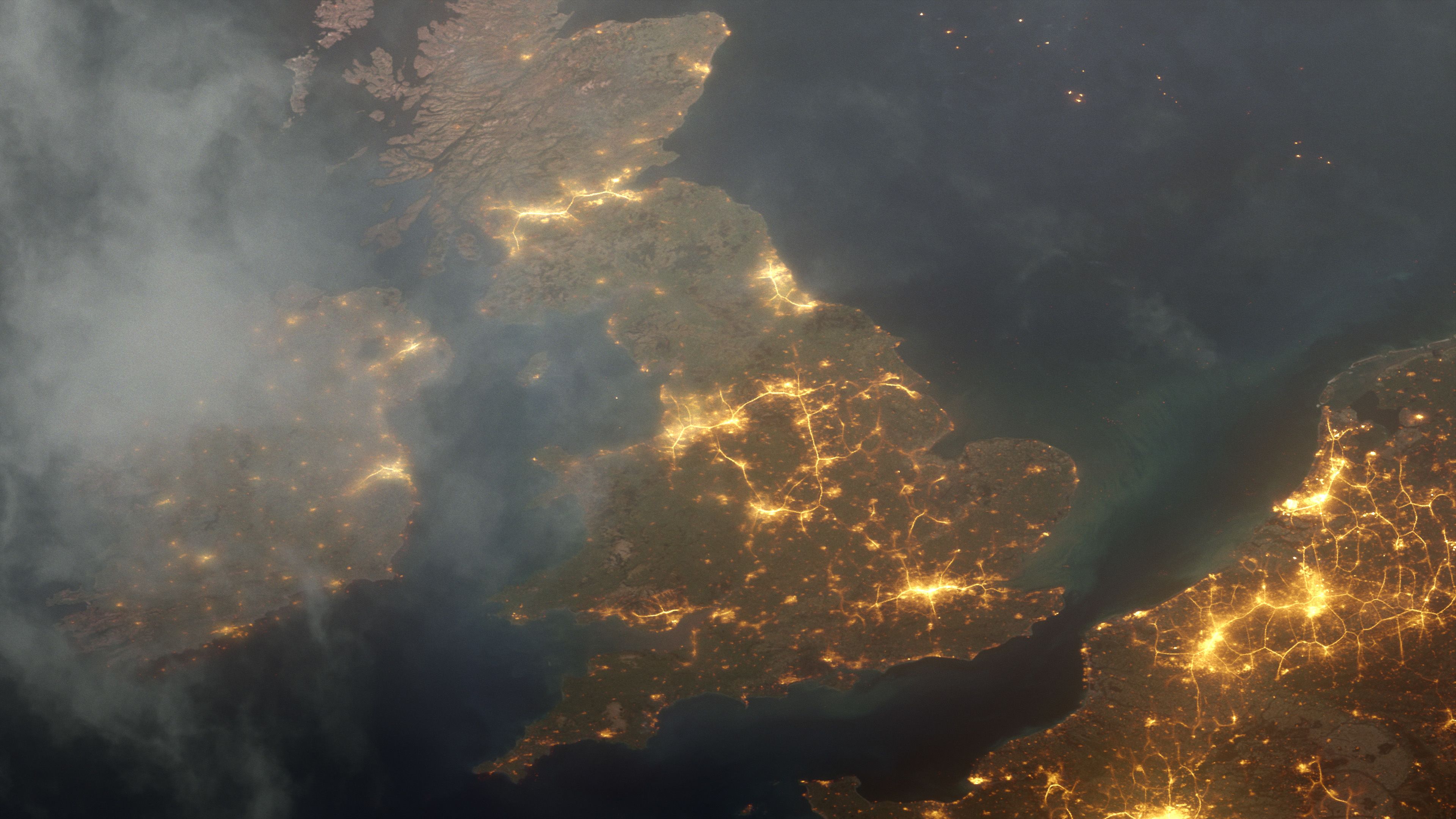 Satellite image of the UK at night. There are lights on across the country lighting up the image