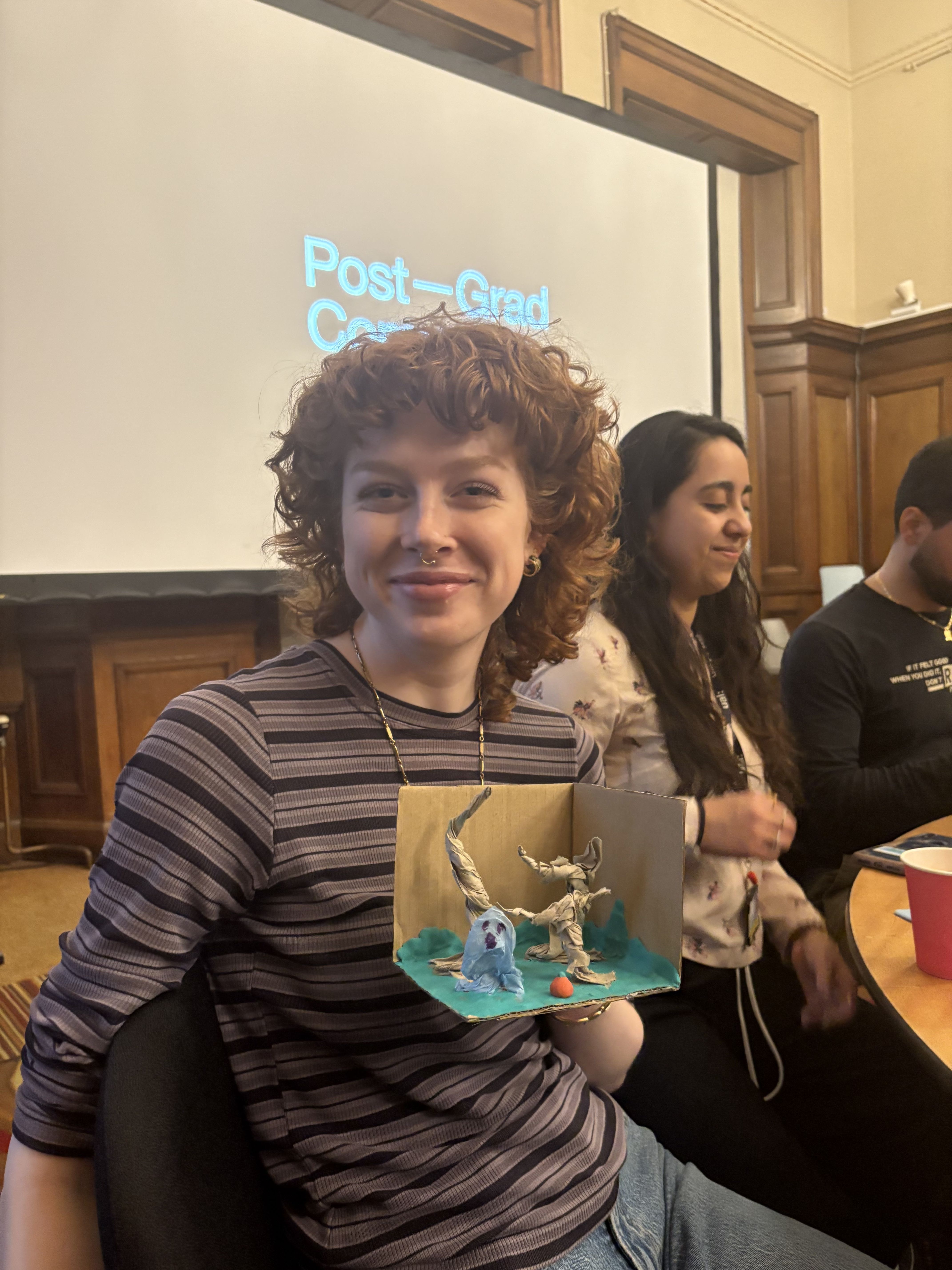 Photo of a person seating at a table looking at the camera