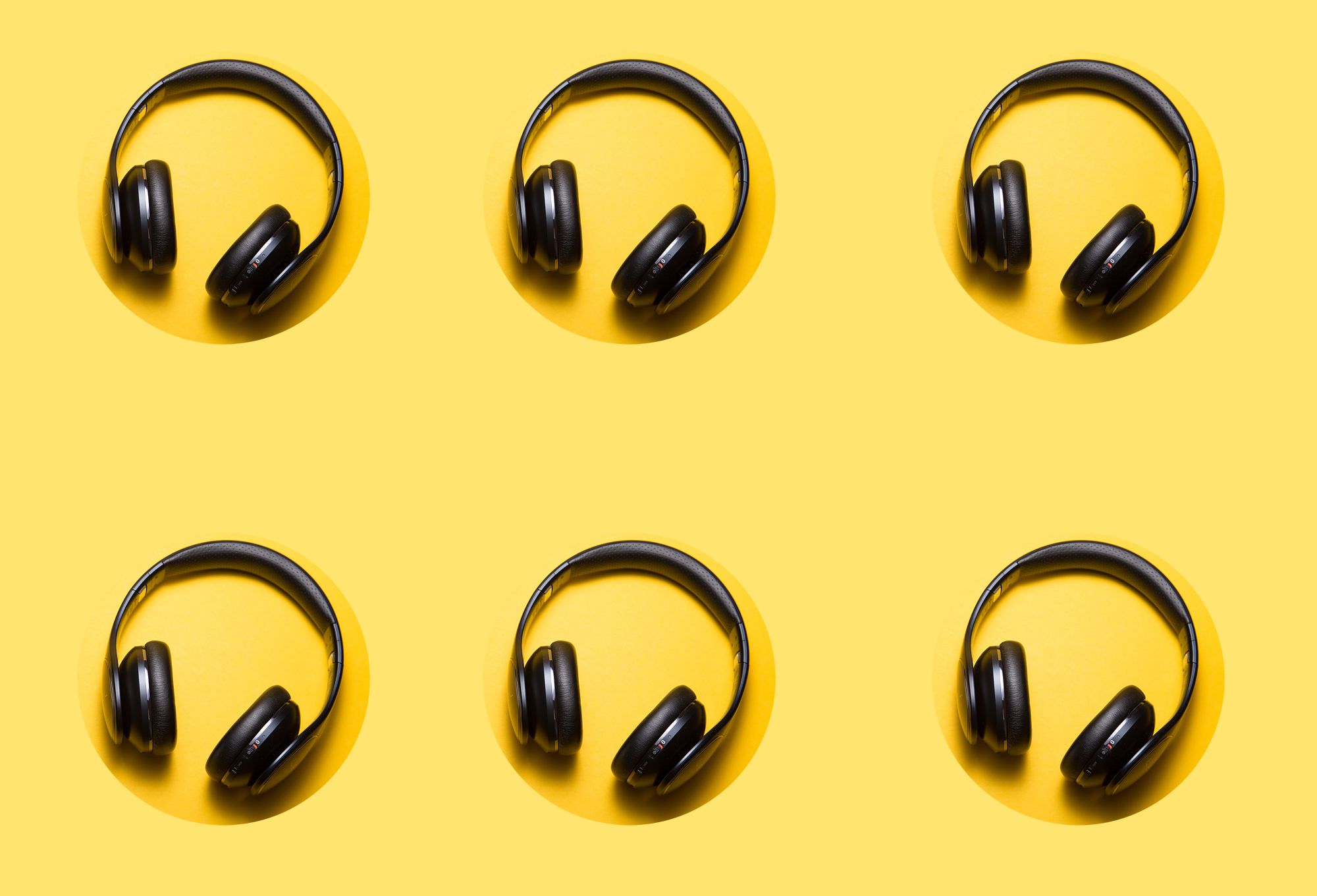 Repeat pattern of 6 black on ear headphones on yellow background