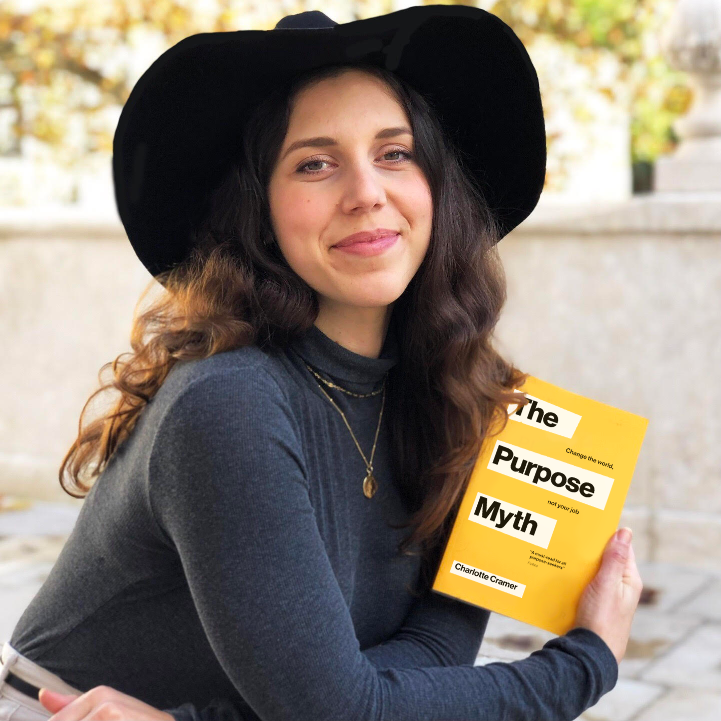 Woman holding a book, looking into camera