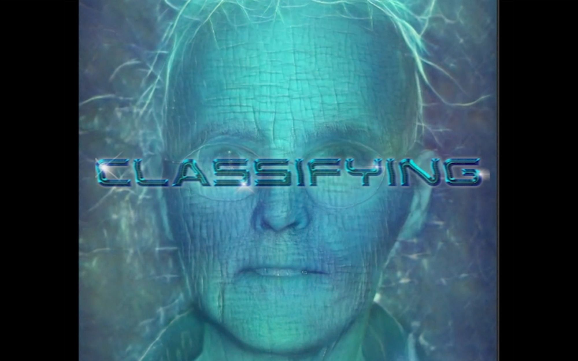 Digitally created image, showing a human male face, subject is wearing glasses and has wrinkled skin. The text ‘classifying’ is overlayed over the face.