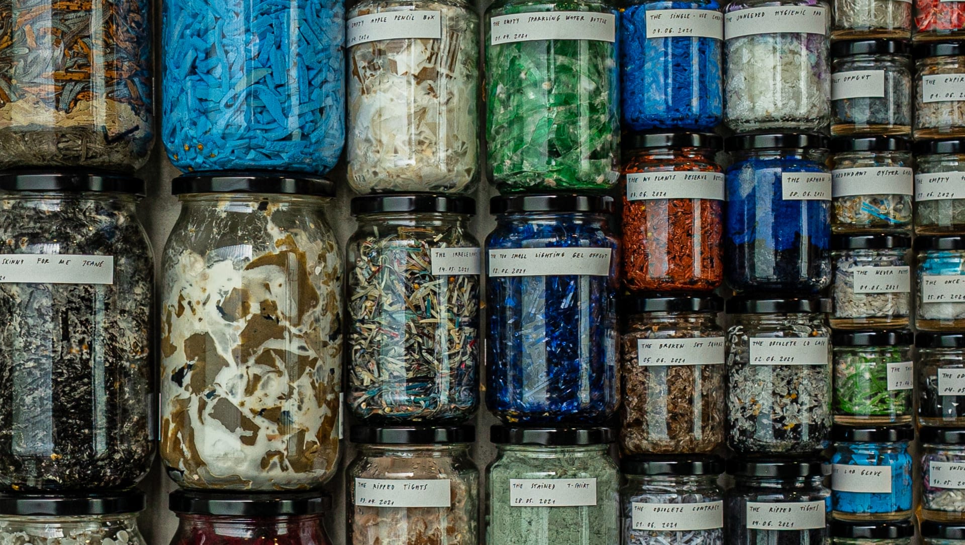 Jars filled with small pieces of plastic and other waste materials